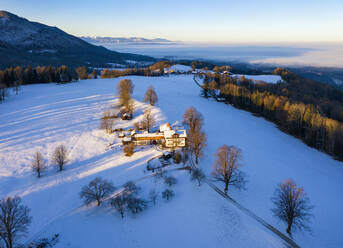 Deutschland, Bayern, Buchberg, Drohnenansicht eines Bergbauernhauses in der Winterdämmerung - SIEF09726