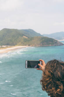 Frau fotografiert Klippen bei Faro del Caballo, Kantabrien, Spanien - FVSF00029