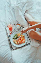 Midsection der Frau mit Frühstück auf dem Bett - EYF02437