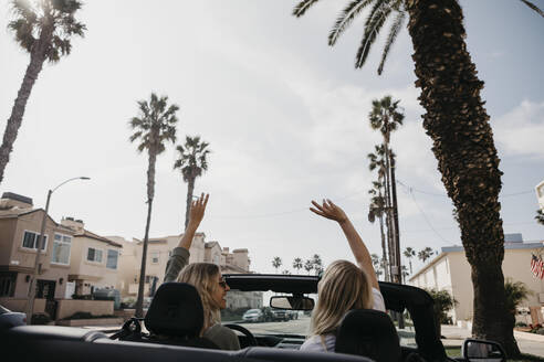 Rückenansicht von zwei jungen Frauen in einem Cabrio, Newport Beach, USA - LHPF01214