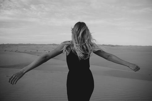 Rückenansicht einer blonden Frau in der Wüste, Algodones Dunes, Brawley, USA - LHPF01217