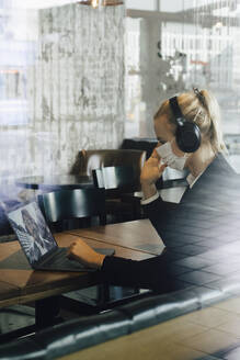 Businesswoman with face mask having video call - MASF17341