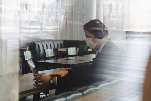 Man wearing face mask working at cafe - MASF17366