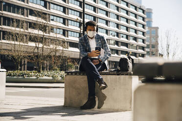 Businessman with face mask using mobile phone - MASF17369