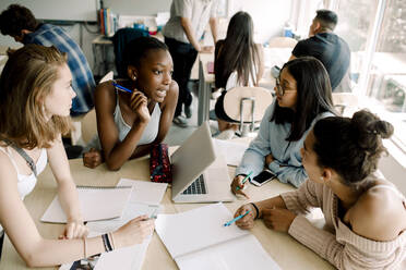 Teenager-Mädchen, die am Tisch im Klassenzimmer sitzen und diskutieren - MASF17376