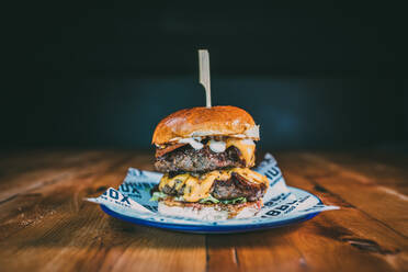 Nahaufnahme von Burger in Teller auf Tisch - EYF02529