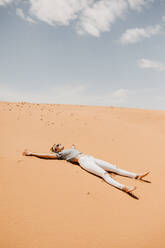 Frau liegend auf Wüste in sonnigen Tag - EYF02657