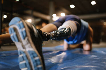 Niedriger Ausschnitt eines Mannes mit Beinprothese, der im Fitnessstudio trainiert - EYF02700