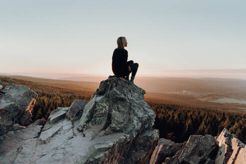 Woman Sitting On Rock Against Landscape - EYF02933