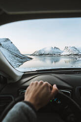 Cropped Hand Of Person Driving Car Against Mountains - EYF02940