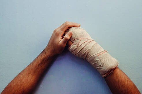 Cropped Hand Of Man Wrapped In Bandage On Table - EYF02943