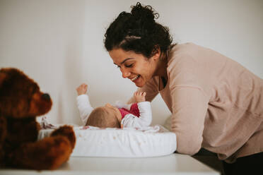 Lächelnde Mutter spielt mit Baby Mädchen zu Hause - EYF02955