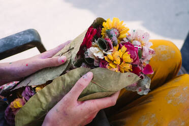 Mittelteil einer Frau, die Blumen hält - EYF02961