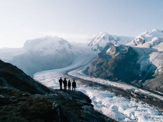 Menschen stehen vor einem schneebedeckten Berg - EYF02992