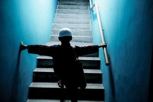 Rückansicht eines Jungen, der auf einer Treppe geht - EYF03018