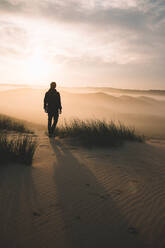 Rear View Of Silhouette Man Standing On Sand At Desert - EYF03026