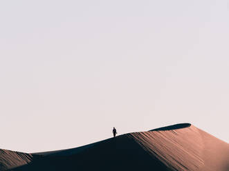 Low Angle View of Silhouette Person stehend auf Sanddüne gegen klaren Himmel - EYF03048
