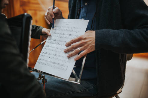 Mittelteil eines Mannes, der einem Schüler Musik beibringt - EYF03072