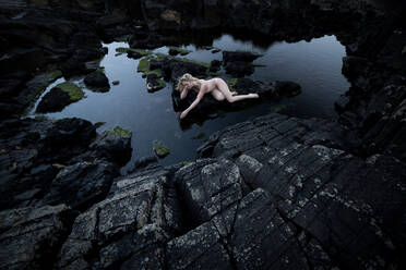 Nackte Frau auf Felsen am See gegen den Himmel - EYF03081