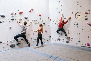 Ausbilder trainiert männliche und weibliche Schüler beim Klettern in der Turnhalle - MASF17538