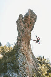 Young woman climbing rock needle in Cantabria, Spain - FVSF00042