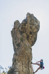 Junge Frau klettert auf Felsnadel in Kantabrien, Spanien - FVSF00044