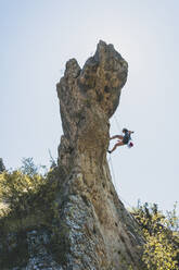 Junge Frau klettert auf Felsnadel in Kantabrien, Spanien - FVSF00045