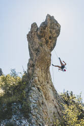Junge Frau klettert auf Felsnadel in Kantabrien, Spanien - FVSF00046