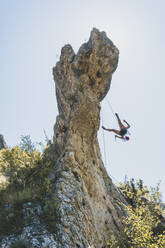 Young woman climbing rock needle in Cantabria, Spain - FVSF00046