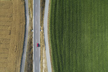 Deutschland, Bayern, Drohne Blick auf Landstraße Schneiden durch grüne und gelbe Landschaft Felder im Sommer - RUEF02714