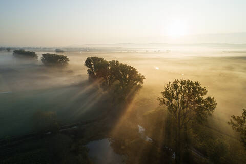 Deutschland, Bayern, Drohnenansicht einer ländlichen Landschaft bei nebligem Sonnenaufgang, lizenzfreies Stockfoto