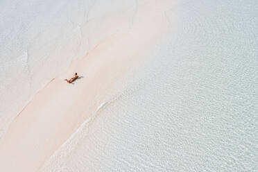 Woman sunbathung on white sand bank in the sea, Bahamas, Carribean - DAWF01314