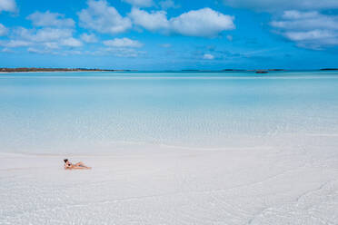 Frau sonnt sich auf einer weißen Sandbank im Meer, Bahamas, Karibik - DAWF01315