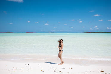 Woman walking on white sand bank in the sea, Bahamas, Carribean - DAWF01326