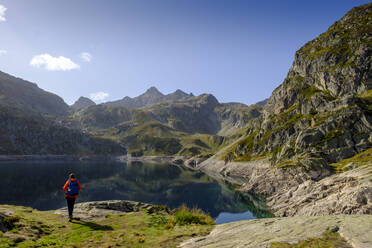France, Pyrenees-Atlantiques, Laruns, Lone hiker at Lac dArtouste in Ossau Valley - LBF03004