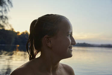 Profil eines glücklichen nassen Mädchens vor einem See in der Abenddämmerung - AUF00328