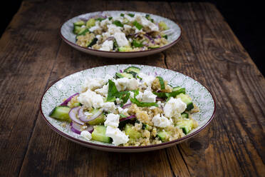 Zwei Teller vegetarischer Salat mit Gurken, Quinoa, Feta-Käse, roten Zwiebeln und Minze - LVF08753