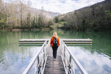 Rückenansicht einer Frau mit Rucksack auf der Promenade, Stausee Valdemurio, Asturien, Spanien - DGOF00676