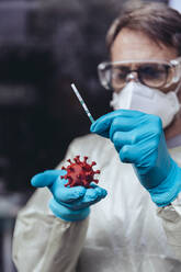 Healthcare worker holding model of Corona Virus and a lateral flow test - MFF05398