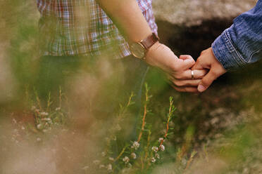 Cropped Couple Holding Hands On Field - EYF03256