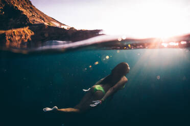 Frau schwimmt in voller Länge im Meer auf den Kanarischen Inseln - EYF03258