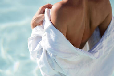 Rear View Of Woman With Bathrobe In Swimming Pool - EYF03316