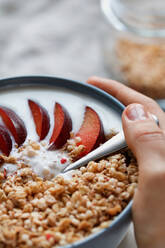 Close-Up Of Hand Holding Bowl Of Fruits - EYF03345