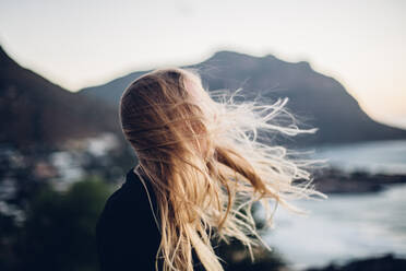 Side View Of Young Woman Standing At Beach Against Clear Sky During Sunset - EYF03395