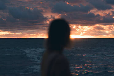 Silhouette Frau am Strand gegen bewölkten Himmel bei Sonnenuntergang - EYF03396