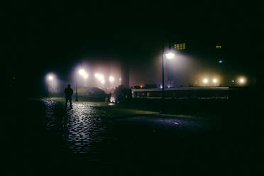 Silhouette Mann stehend auf Straße bei Nacht - EYF03420