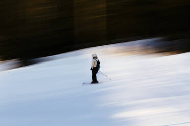Unscharfe Bewegung der Person Skifahren auf schneebedeckten Berg - EYF03459