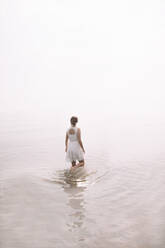 Full Length Of Woman Wading In Sea Against Clear Sky - EYF03463