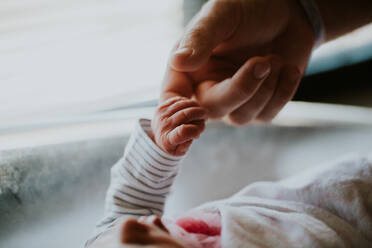 Nahaufnahme von Baby hält Hand auf Bett - EYF03492