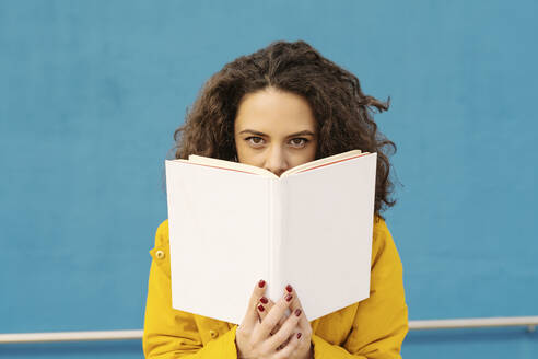 Portrait of young woman woman in front of blue wall - JCZF00045